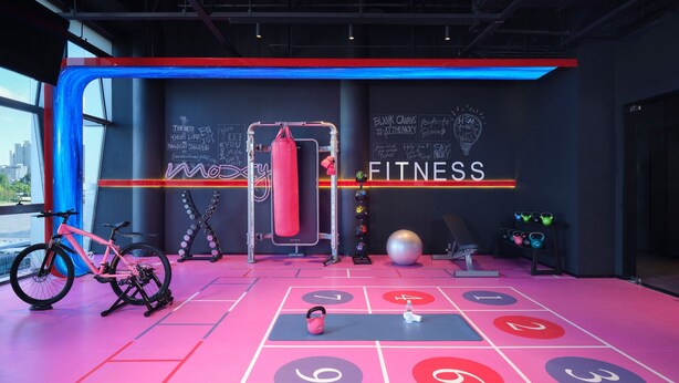 A modern fitness center with a large punching bag, a stationary bike, and a variety of weights. - Moxy Ningbo Old Bund (Ningbo)