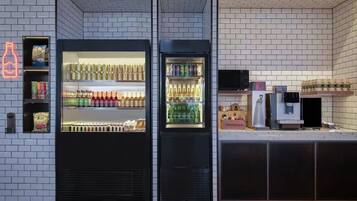 Un moderno carrito de bebidas con dos vitrinas refrigeradas, una máquina de café y una barra con una caja registradora.