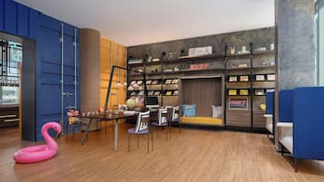 A modern interior with a dining area, a bookshelf, and a blue partition.