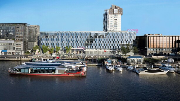 A modern building with a glass facade and a tall tower. - Moxy Ningbo Old Bund (Ningbo)