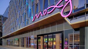 A modern building with a prominent neon sign spelling "mo" and a geometric facade. - Moxy Ningbo Old Bund (Ningbo)