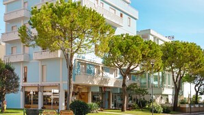 Un edificio a più piani con balconi, un cartello sulla spiaggia e un ristorante chiamato "Italia".