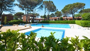 A swimming pool surrounded by greenery and buildings.