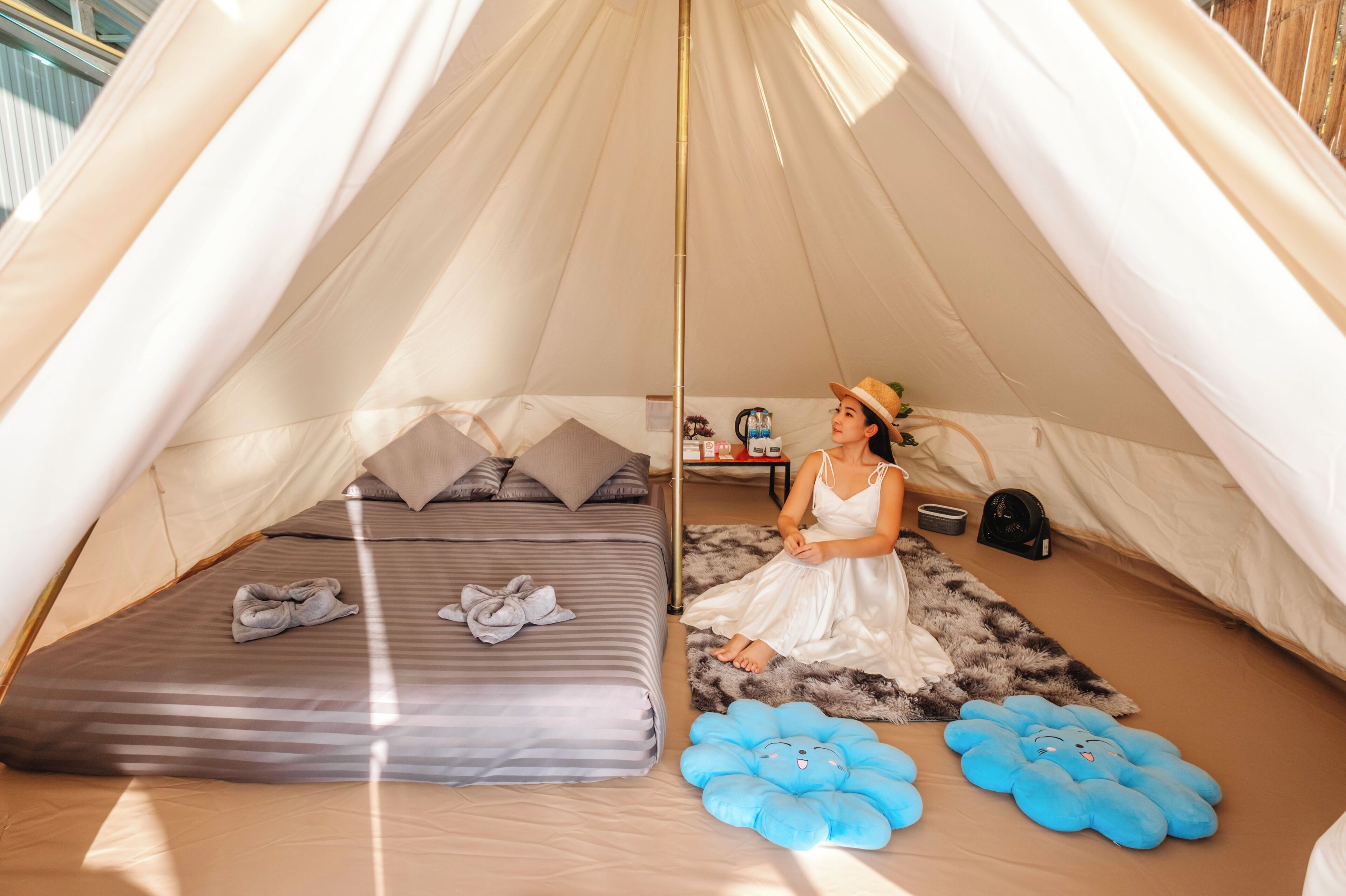 A tent with a bed, pillows, a blanket, and a blue plush toy.
