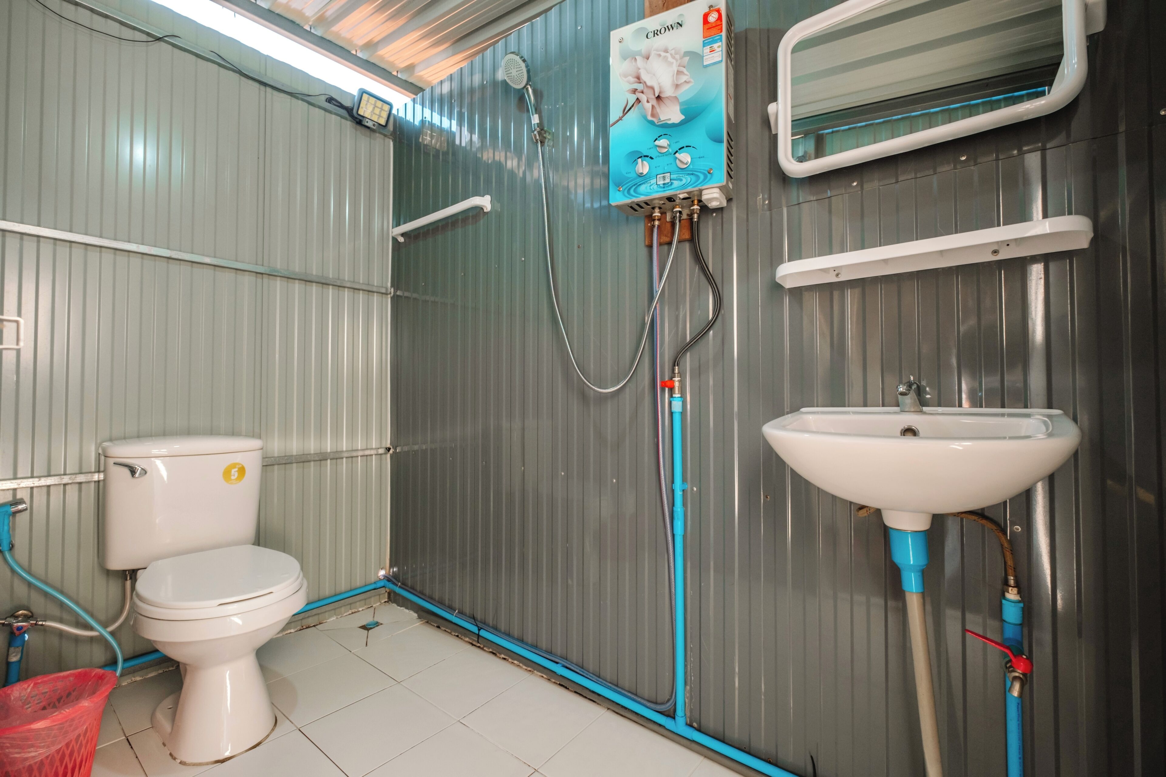 Een kleine badkamer met toilet, wastafel en douche.