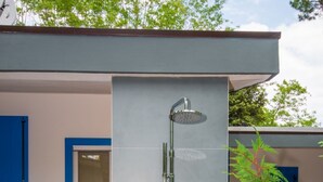 Eine moderne Duschkabine mit Regendusche, Handbrause und separatem Wasserhahn.