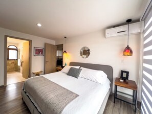 Relax in a spacious room with a large bed, bedside table, and mirror.