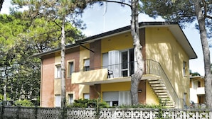 A two-story building with a yellow facade, a balcony, and a staircase leading to the upper floor. - Villa Verde by Interhome (Bibione)