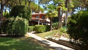 A house surrounded by lush greenery, including trees and shrubs. - Villaggio Euro Residence Club by Interhome (Bibione)