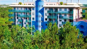 Un hôtel moderne à plusieurs étages, doté de balcons et entouré de verdure.