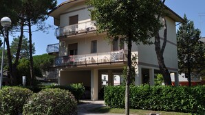 A multi-story building with balconies, surrounded by trees and greenery. - Villa Stefano by Interhome (Bibione)