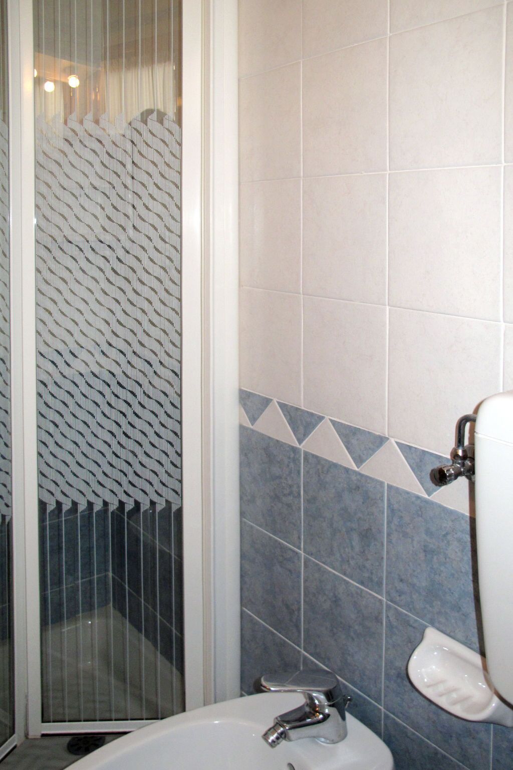 Une salle de bain avec une douche, un lavabo et un miroir.