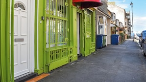 Vista de la calle con un edificio verde que tiene un letrero de restaurante.