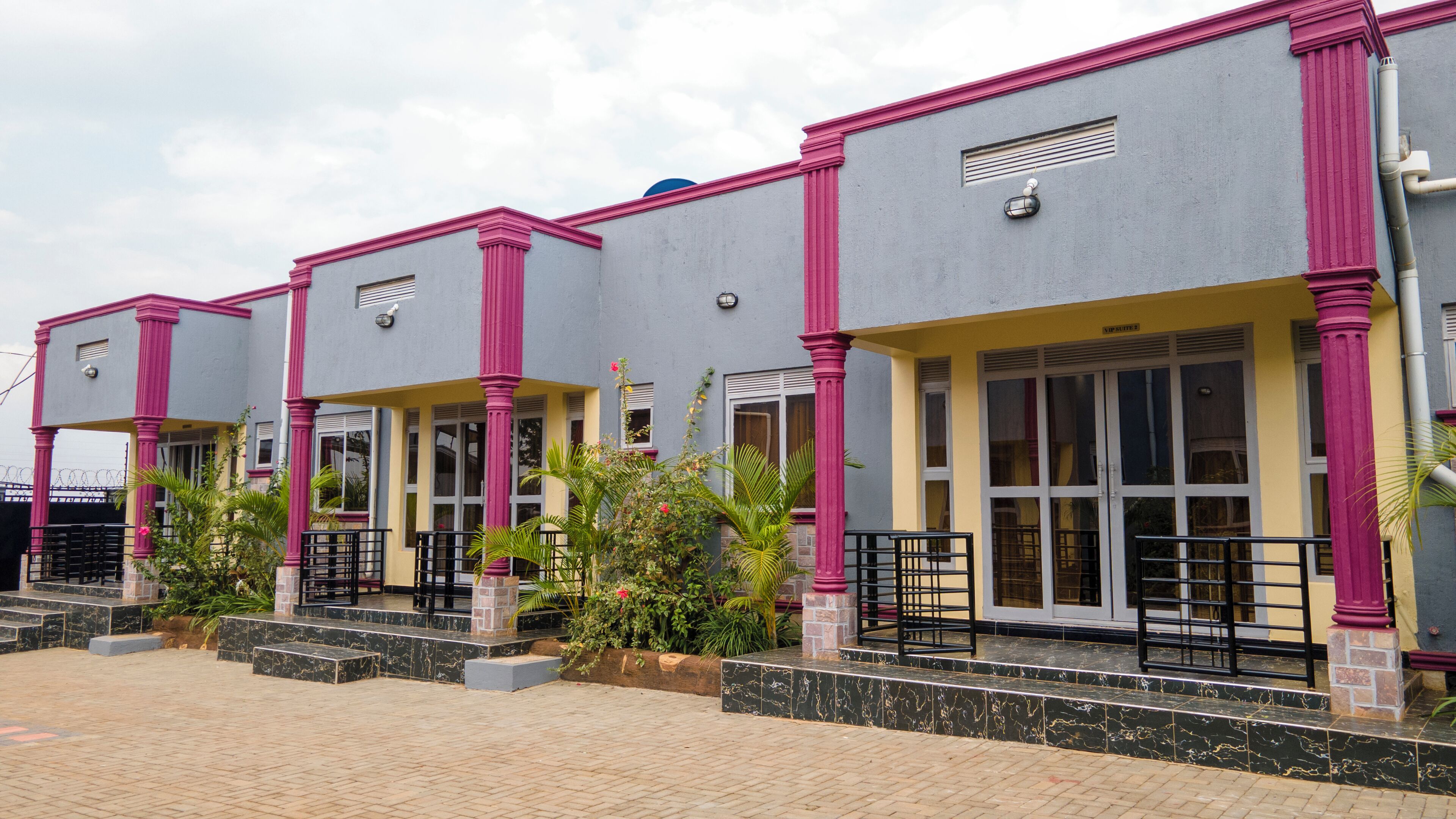 A row of buildings with a consistent architectural style, featuring large windows and a central entrance with a staircase.
