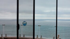 Vista al mar a través de una ventana, con piso de baldosas y una escultura decorativa de pelícano.