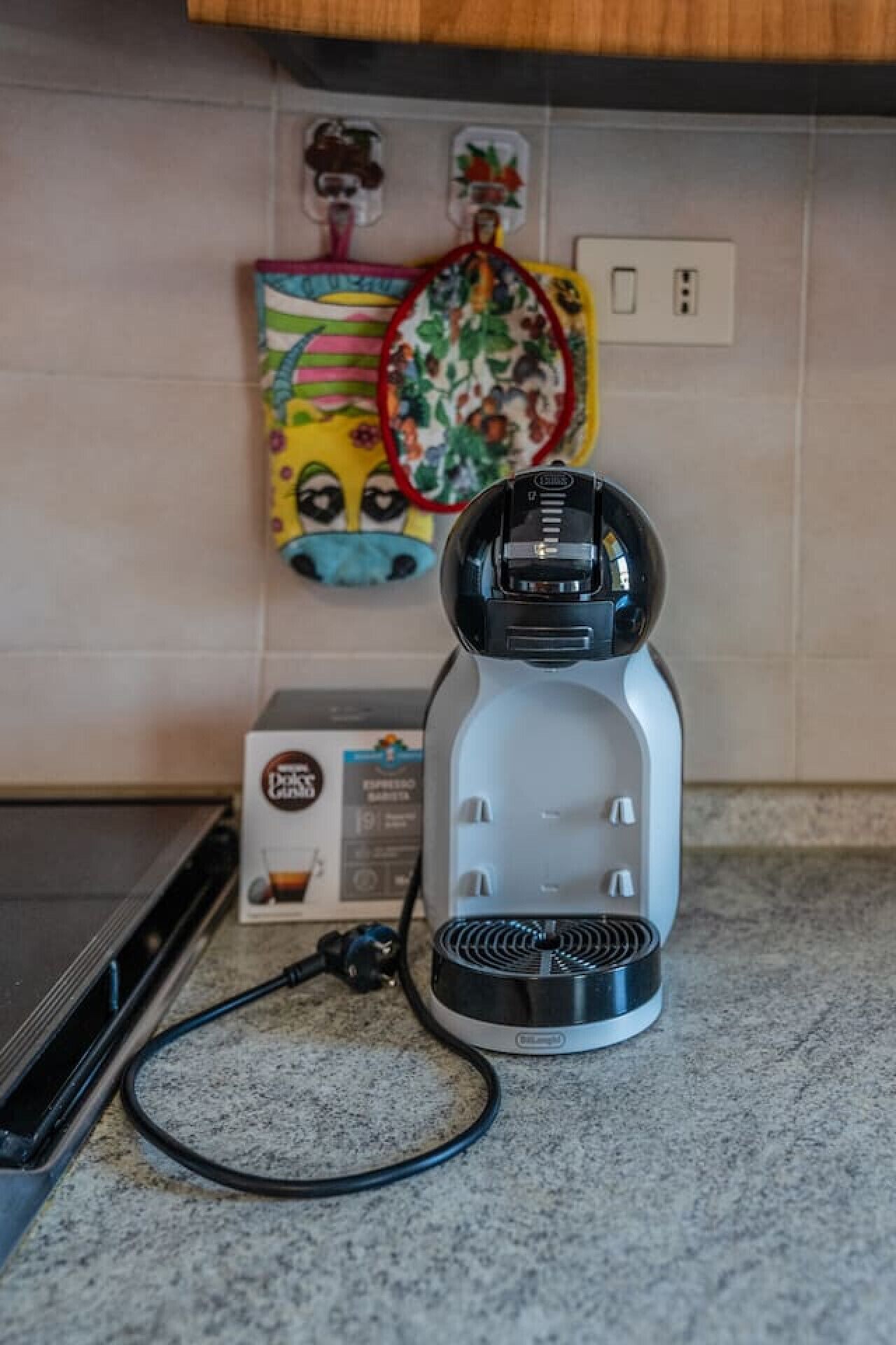 Eine Kaffeemaschine auf einer Küchenarbeitsplatte mit einer Schachtel daneben.
