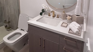 A modern bathroom with a toilet, sink, and mirror. - Spacious Apartment in Prime West Hollywood - Steps from Restaurants & Night life (Los Angeles)