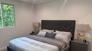 A modern bedroom with a large bed, two bedside tables, a window, and a ceiling light. - Spacious Apartment in Prime West Hollywood - Steps from Restaurants & Night life (Los Angeles)