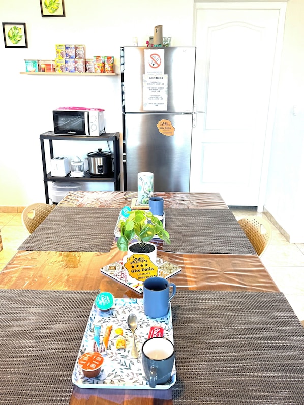 A dining table with a tray of food, a mug, and a plant.