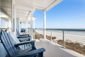 A covered deck with blue Adirondack chairs overlooking a beach. - Front Beach Condo! 1 Block to Center Street-3C (Folly Beach)
