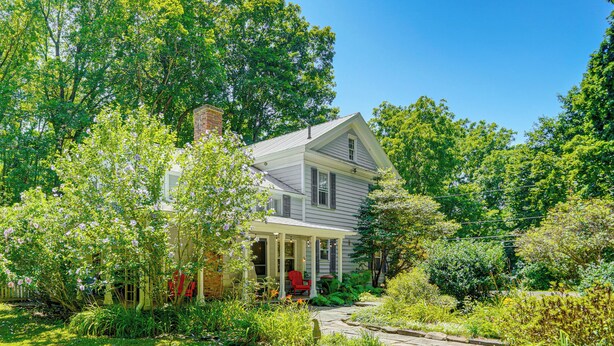 A two-story house with a covered porch and a garden. - Historic Catskills Farmhouse: Ski, Hike & Relax! (Catskill)