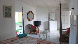 Une chambre à coucher comprenant un lit, une télévision, une commode, un miroir et un réfrigérateur.