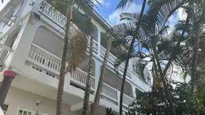 Un immeuble à plusieurs étages doté de balcons et bordé de palmiers.