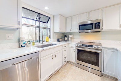 Golf course-front condo with screened sunroom & minutes from beach
