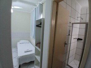 A small, clean room with a single bed, a shower, and a wardrobe. - Hotel Aconchegante (Jequie)