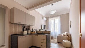 Eine moderne Küche mit einer zentralen Kochinsel, eingebauten Schränken und einem Essbereich mit einer Couch und einem Couchtisch.