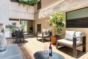 A modern outdoor seating area with a table, chairs, and a potted plant. - Caliza Roma Residences by Tasman (Mexico City)