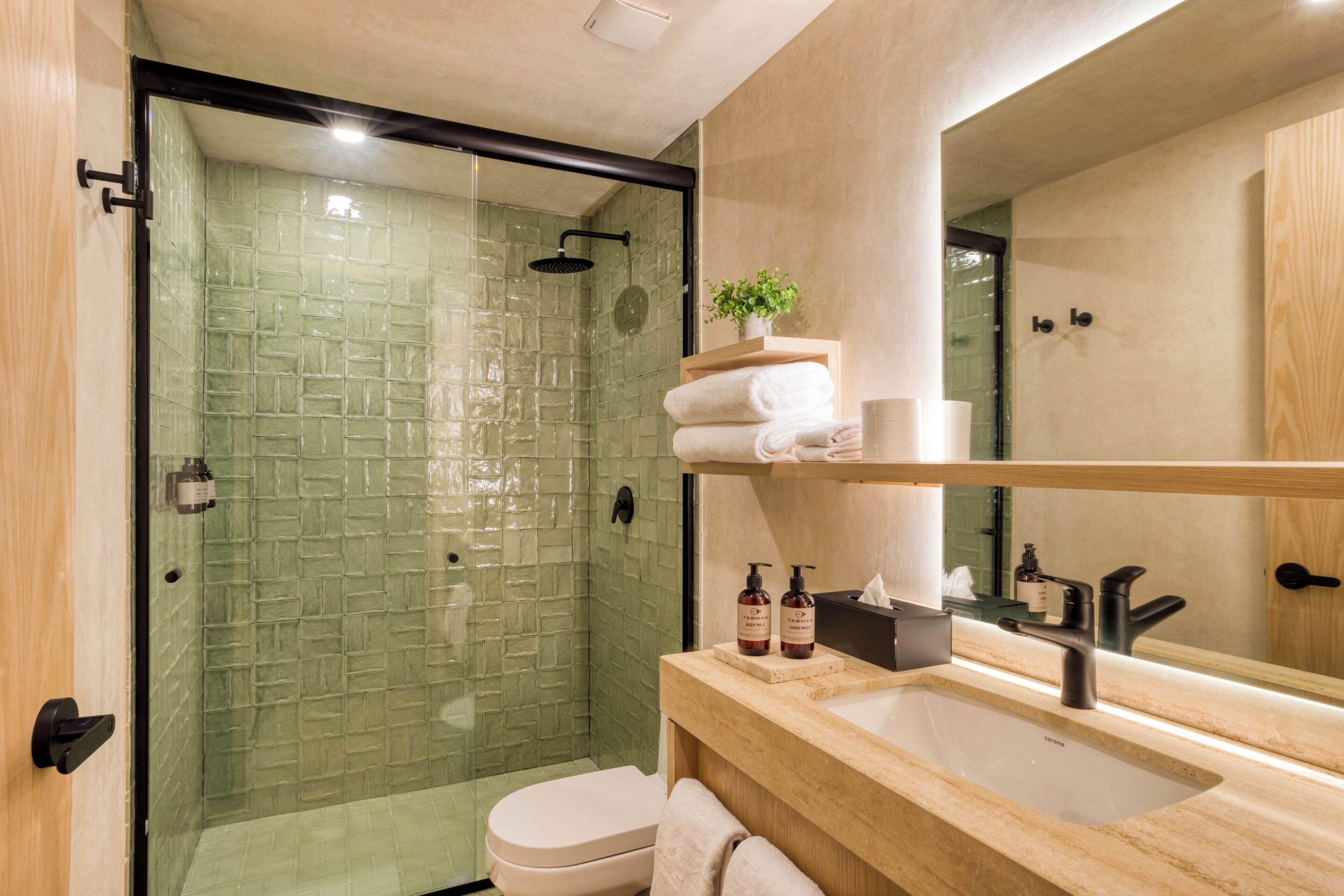 A modern bathroom with a glass-enclosed shower, a wooden vanity with a sink, and a mirror above the vanity.
