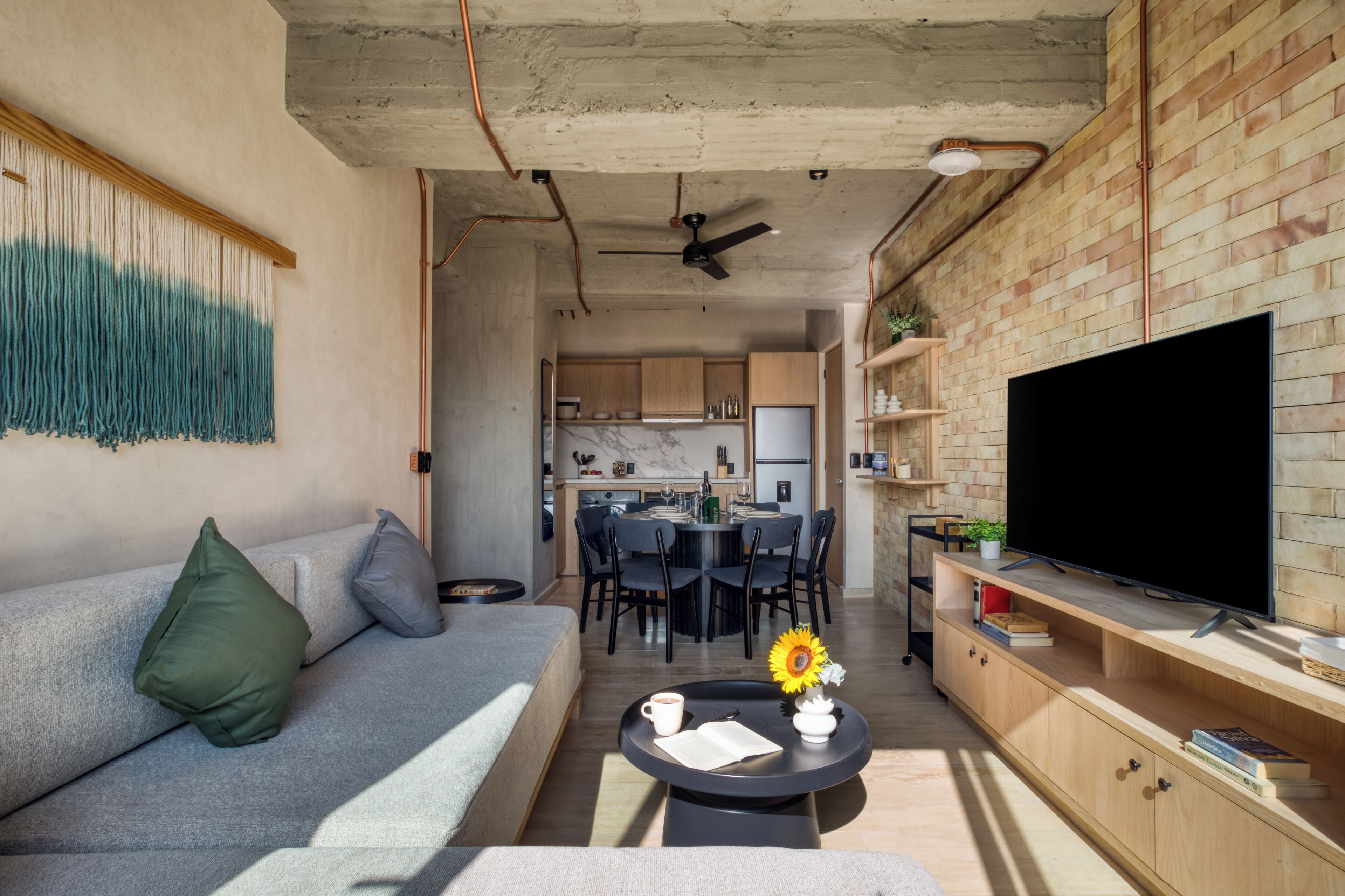 Una sala de estar moderna con sofá, mesa de centro y televisor.