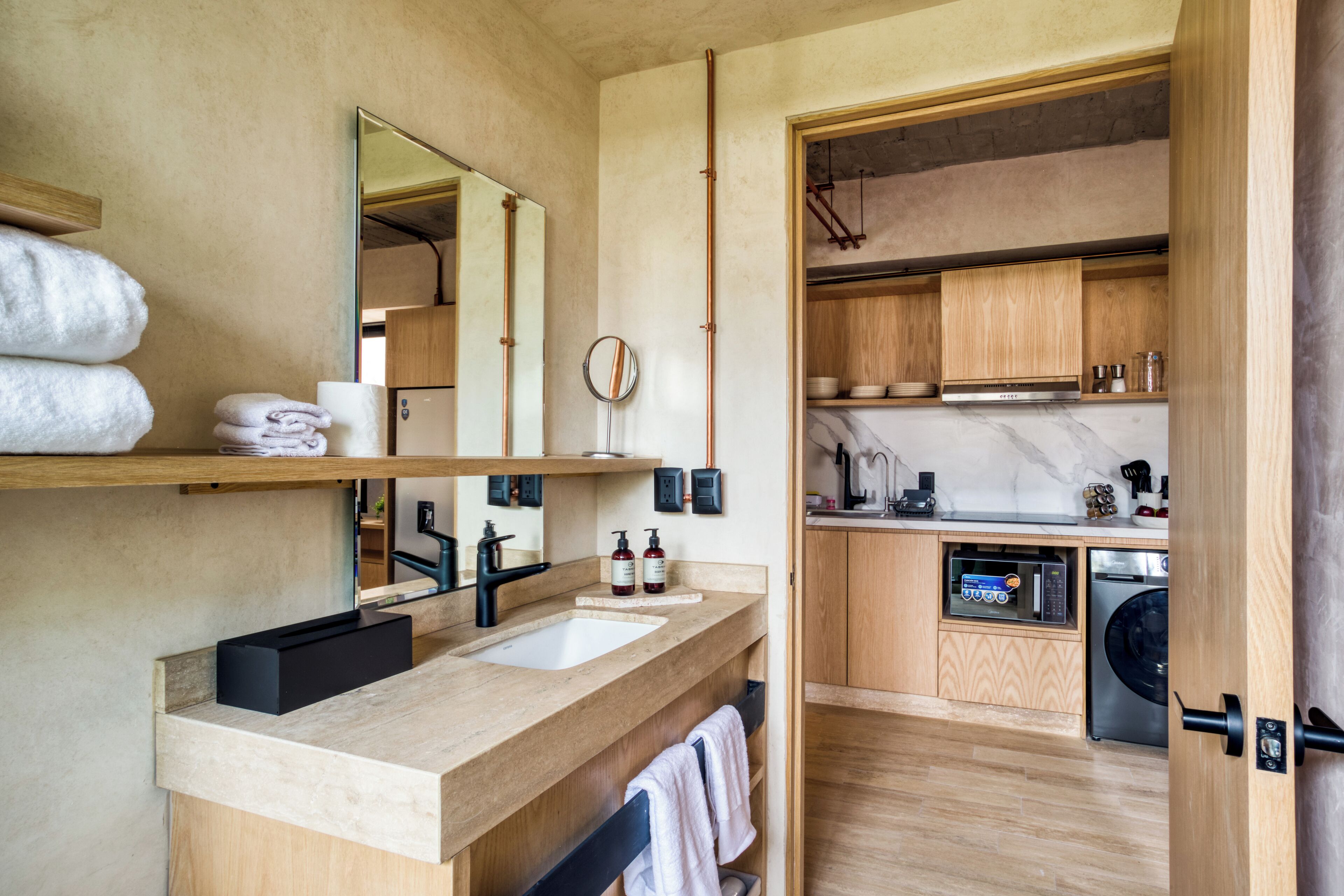 A modern bathroom with dual sinks, a large mirror, and a wooden vanity.