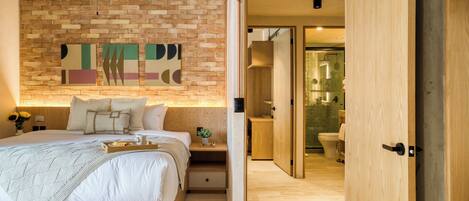 A modern bedroom with a brick wall, a ceiling fan, a bed with a tray of items, and a wooden wardrobe.