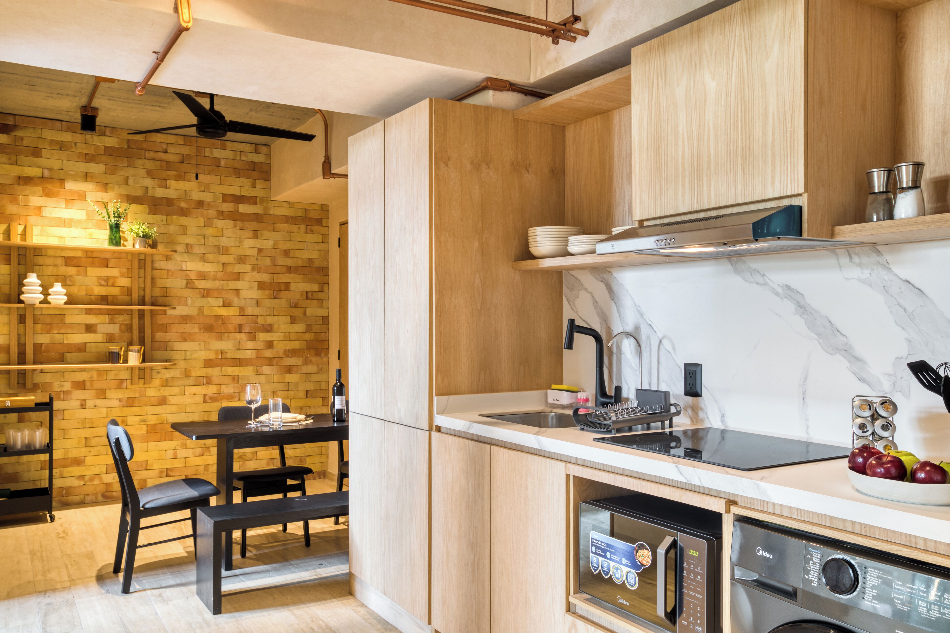 Une cuisine moderne avec des meubles en bois, un plan de travail en marbre et des appareils électroménagers intégrés.
