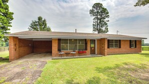 Een huis met één verdieping, gebouwd van baksteen, met een overdekte veranda, een voordeur en een klein voortuintje.