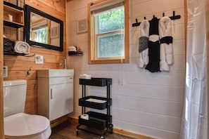 A compact bathroom with a toilet, sink, and towel rack. - Cozy cabin in charming Cosby with AC (Cosby)