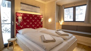 Ein Zimmer aus Holz mit einem Bett, einer Bank und einem Fenster.