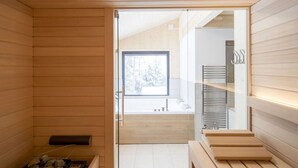 Une salle de bain moderne avec un intérieur en bois, une douche en verre et une vue dégagée sur l’extérieur.