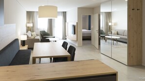 A modern hotel room with a dining area, a sofa, a TV, and a sliding door leading to a bedroom. - mit 1 Schlafzimmer Ski-in/Ski-out by Interhome (Treffen)