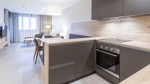 A modern kitchen with dark cabinets, a wooden countertop, and a built-in oven. - mit 1 Schlafzimmer Ski-in/Ski-out by Interhome (Treffen)