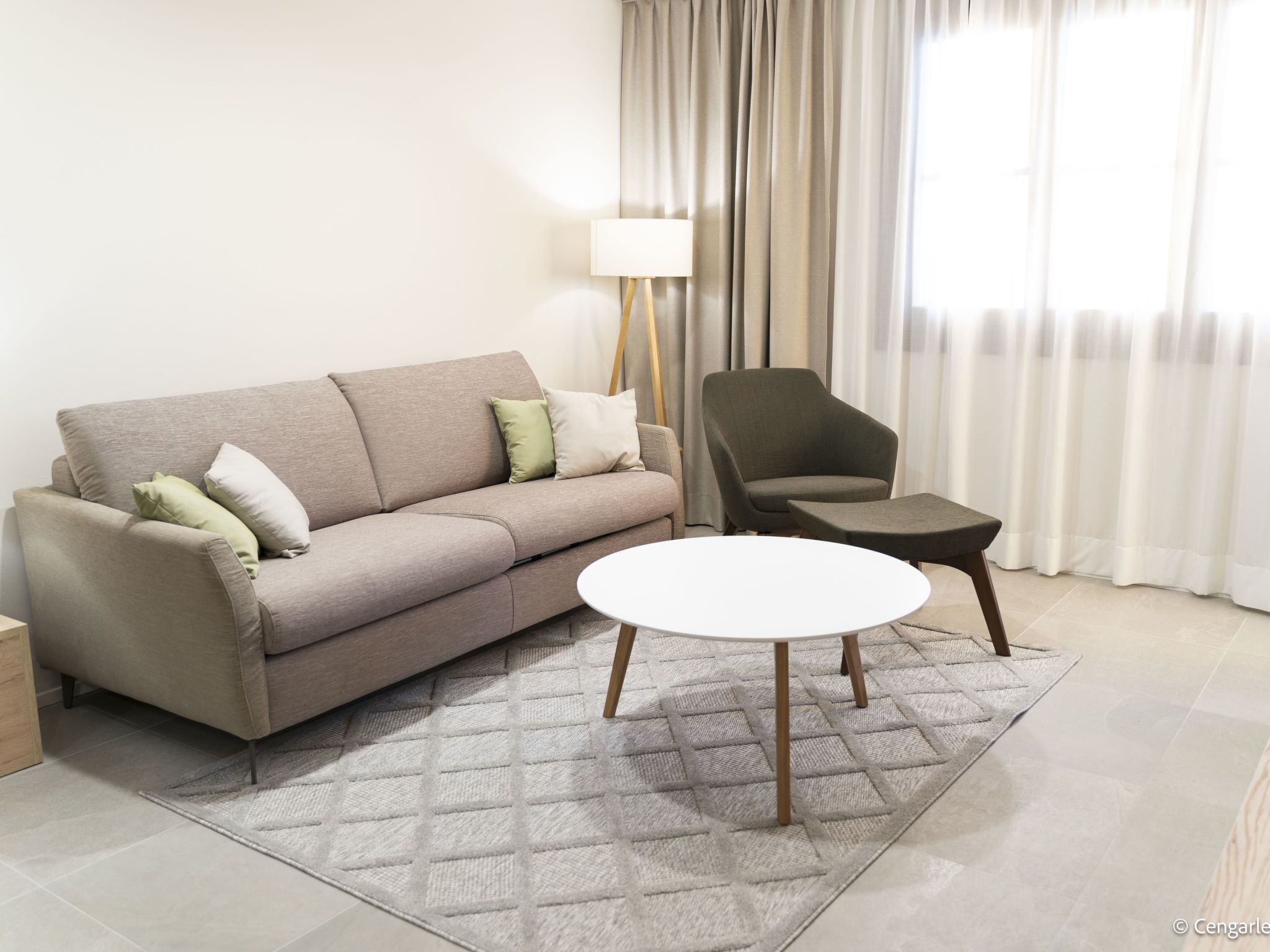 A living room with a sofa, a chair, a small table, and a lamp.