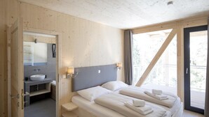 Une pièce en bois avec un lit, une salle de bain et un balcon.