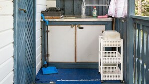 Une petite cuisine rustique avec une fenêtre, un évier et un étendoir.