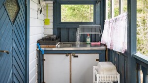 Une petite cuisine équipée d’une fenêtre, d’un évier, d’une cuisinière et d’un égouttoir.