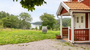 A house with a porch, a view of a lake, and a forest in the background. - Klinten Totebo by Interhome (Totebo)
