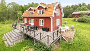 A red wooden house with a deck and outdoor furniture. - Klinten Totebo by Interhome (Totebo)