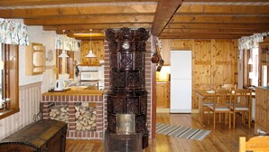 Una cucina rustica con pareti in legno, un camino in mattoni e una zona pranzo in legno.