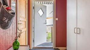 Ein Flur mit einer Holztür, einem weißen Schrank und einer grünen Vase auf einer Theke.